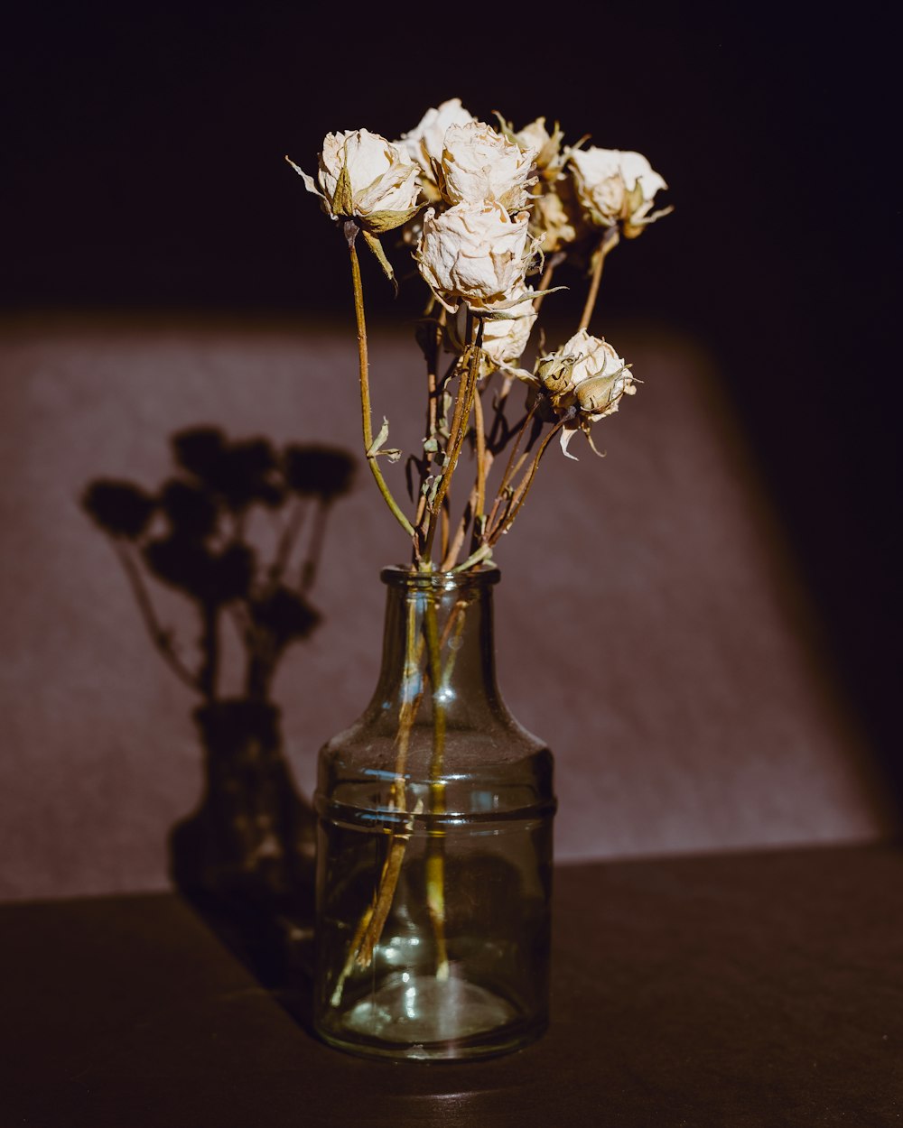 white roses in clear glass vase