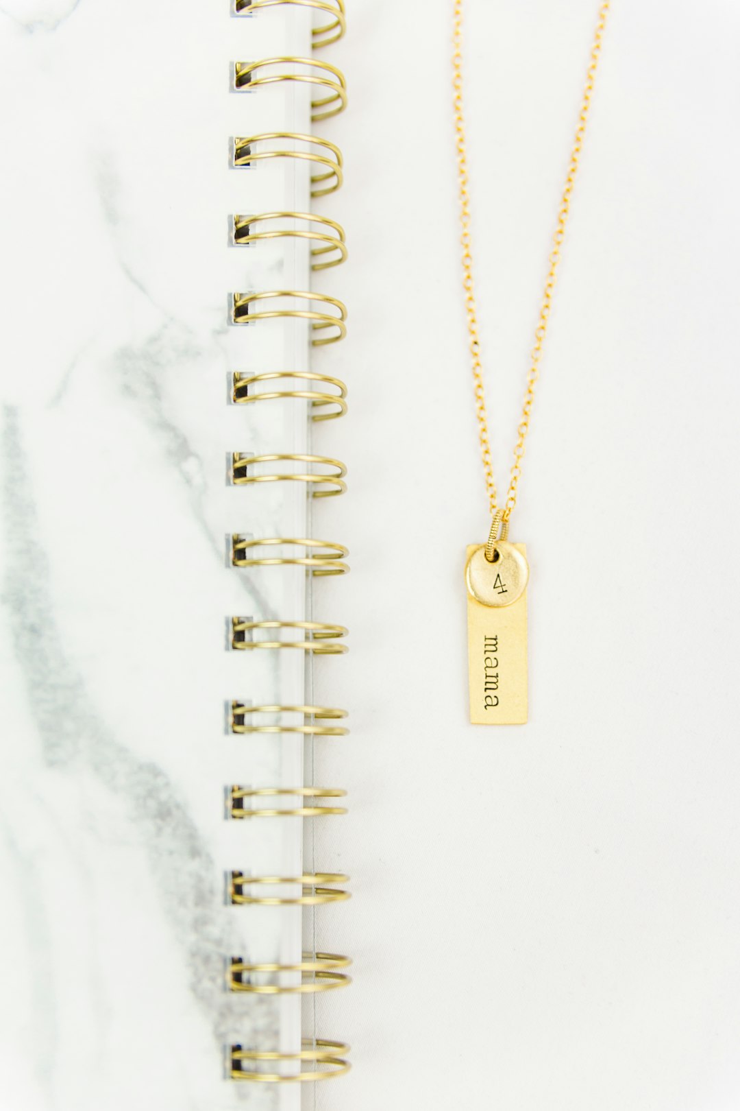 gold chain necklace on white paper