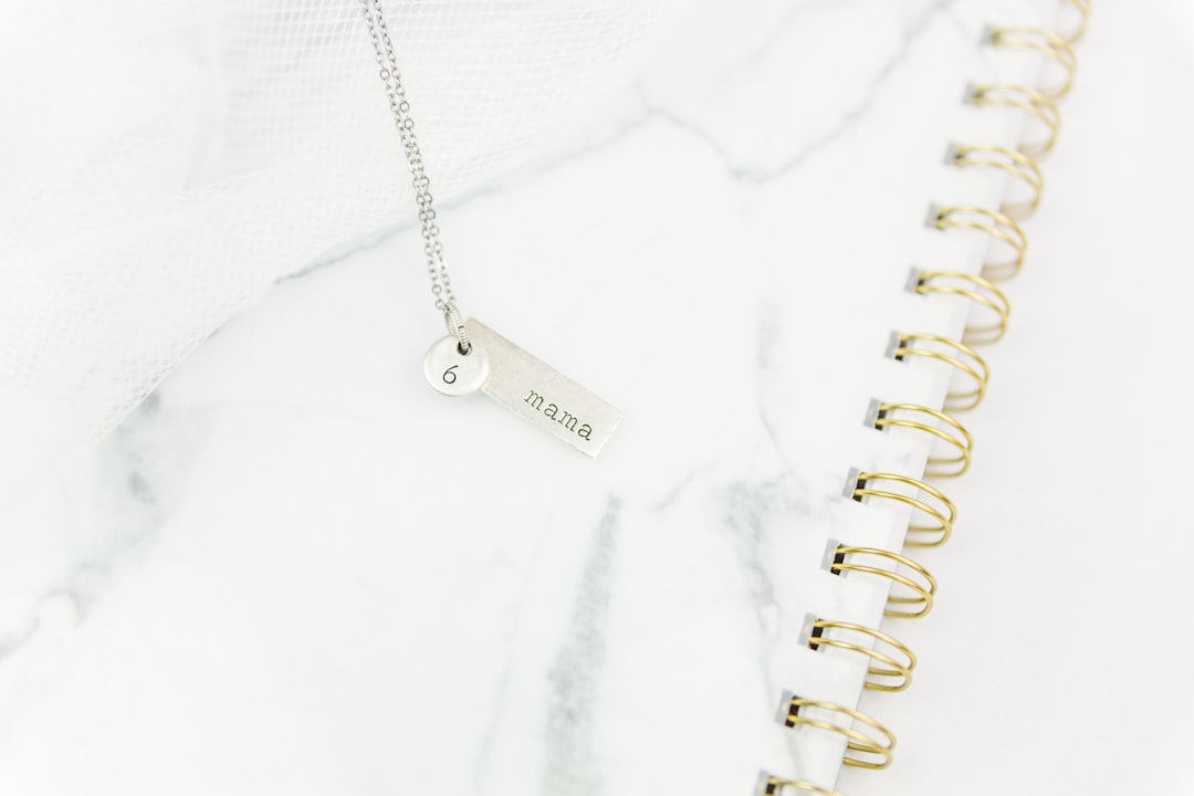 silver key chain on white textile