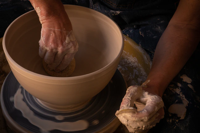 An instructor demonstrating hand-building techniques with clay slabs.