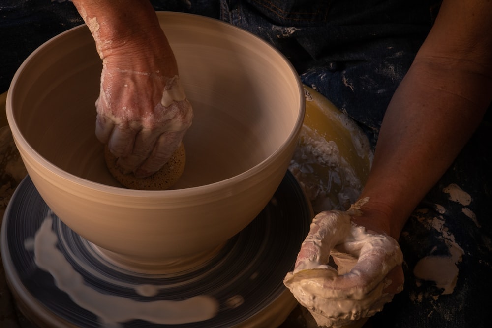 白い陶器の壺を持つ人