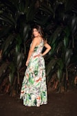 A vibrant dress displayed on a model against a nature backdrop.