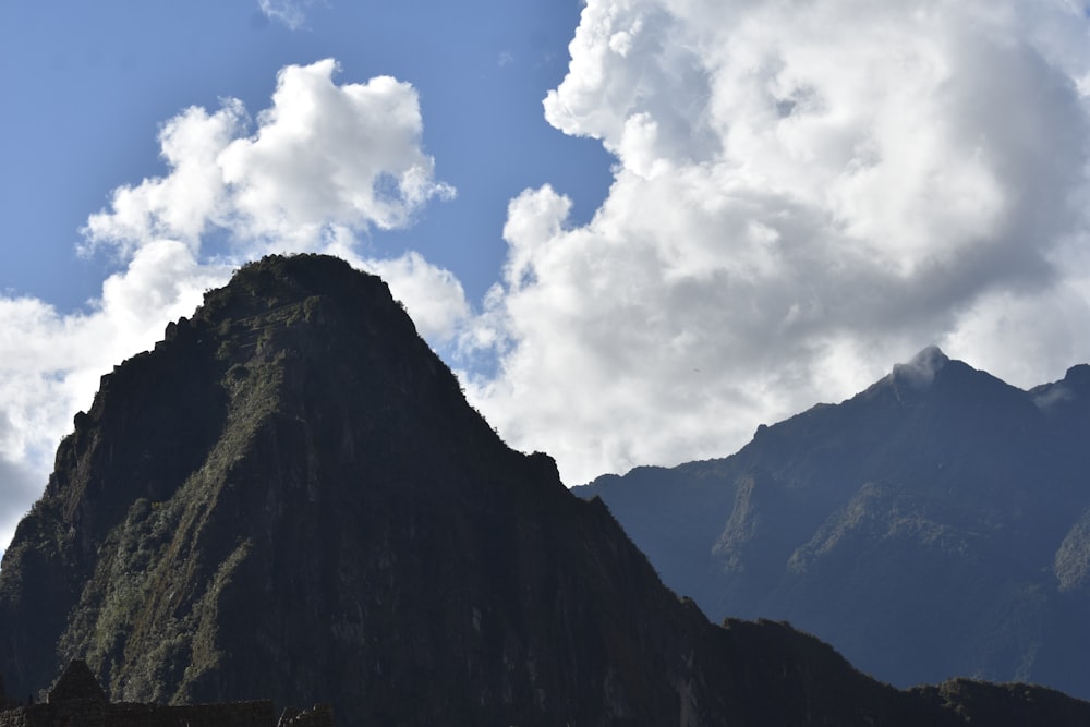 green and brown mountain under white clouds and blue sky during daytime