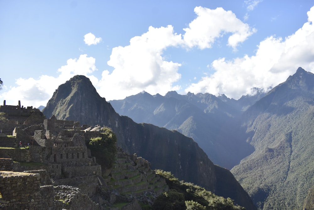 brown concrete building on top of mountain under white clouds during daytime