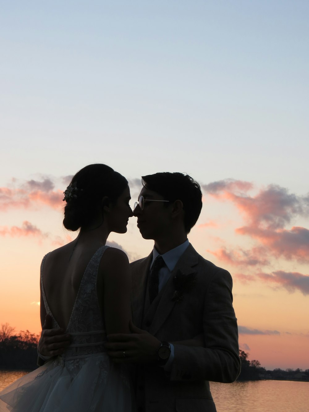 hombre y mujer de pie uno al lado del otro durante la puesta del sol