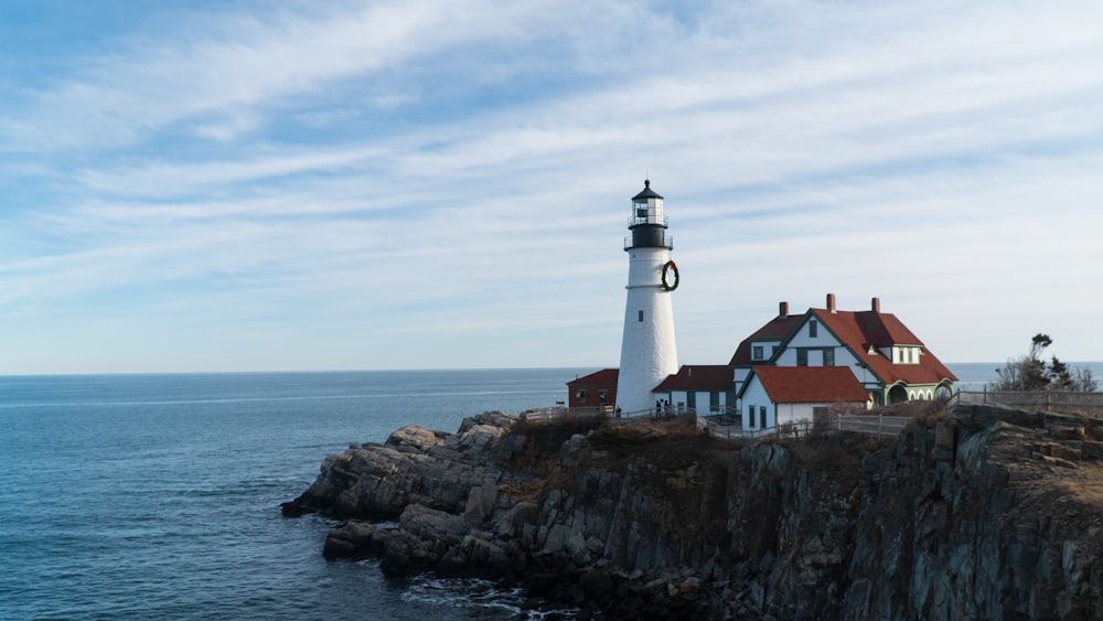 white and brown lighthouse near body of water during daytime