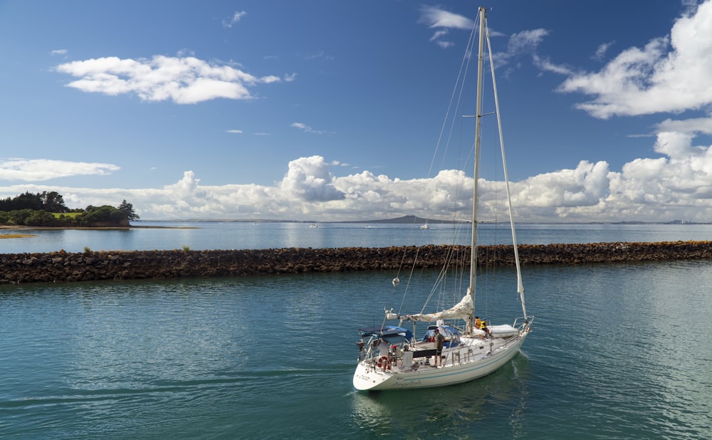 white boat on sea under blue sky during daytime