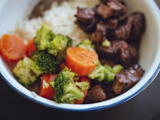 cooked rice with broccoli and carrots in blue ceramic bowl