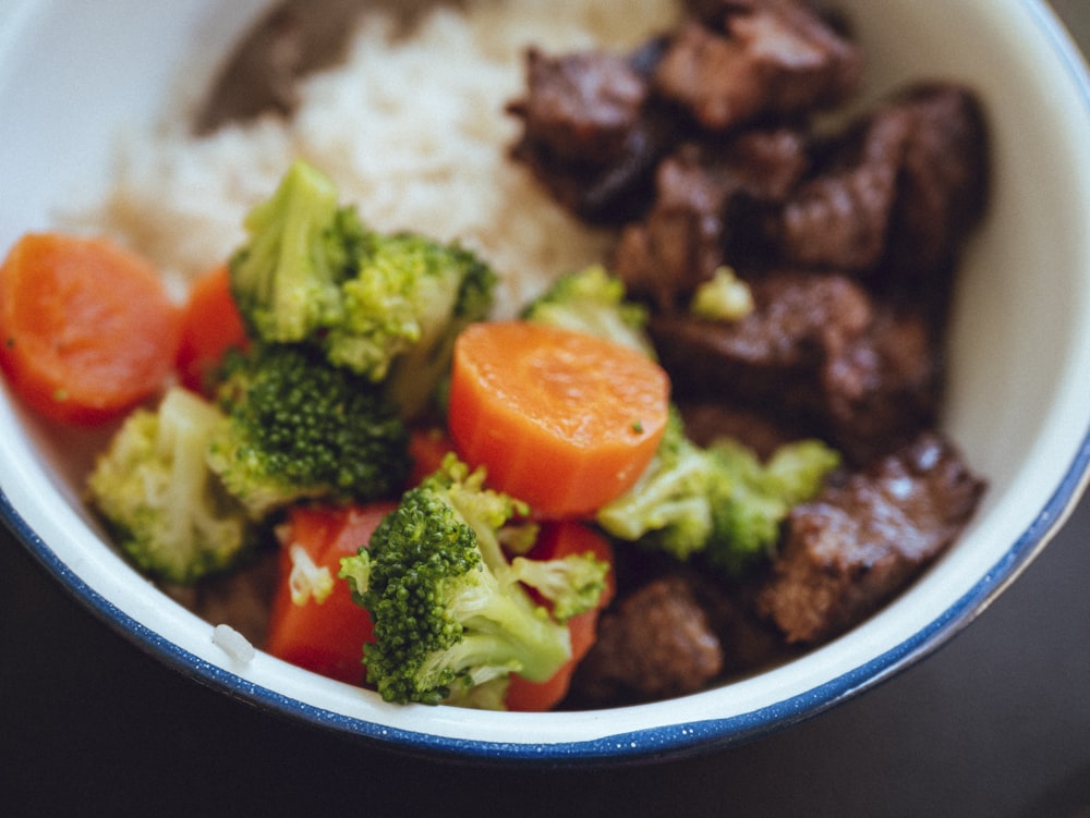 riz cuit avec brocoli et carottes dans un bol en céramique bleue