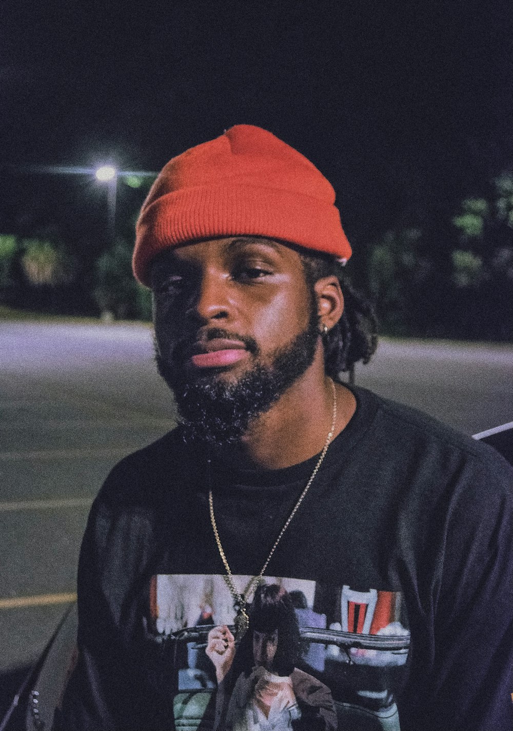 man in black crew neck t-shirt wearing orange cap