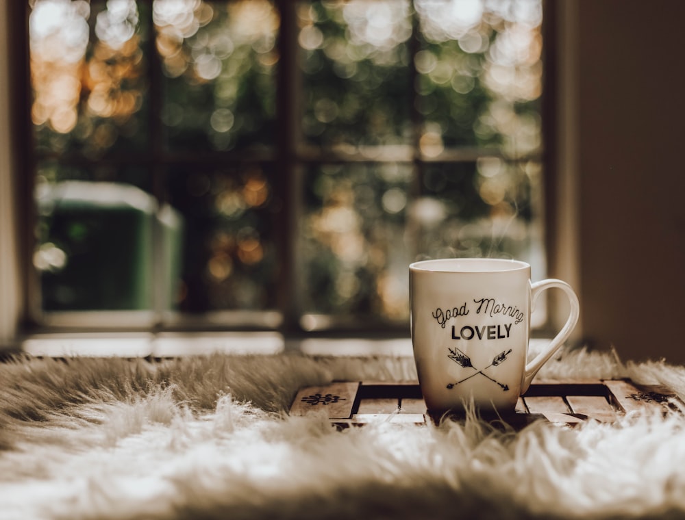 Mug en céramique blanche sur dessous de verre en bois marron