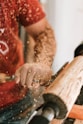 man in red and white nike crew neck t-shirt holding brown wooden rolling pin