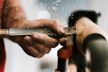 person holding silver and orange pipe