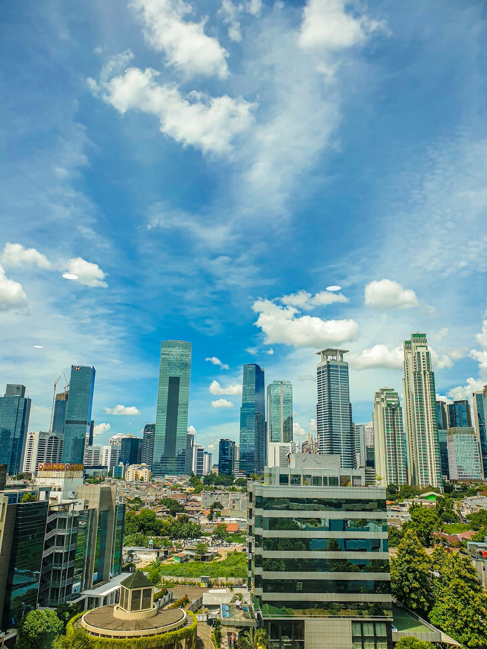 city skyline under blue and white cloudy sky during daytime