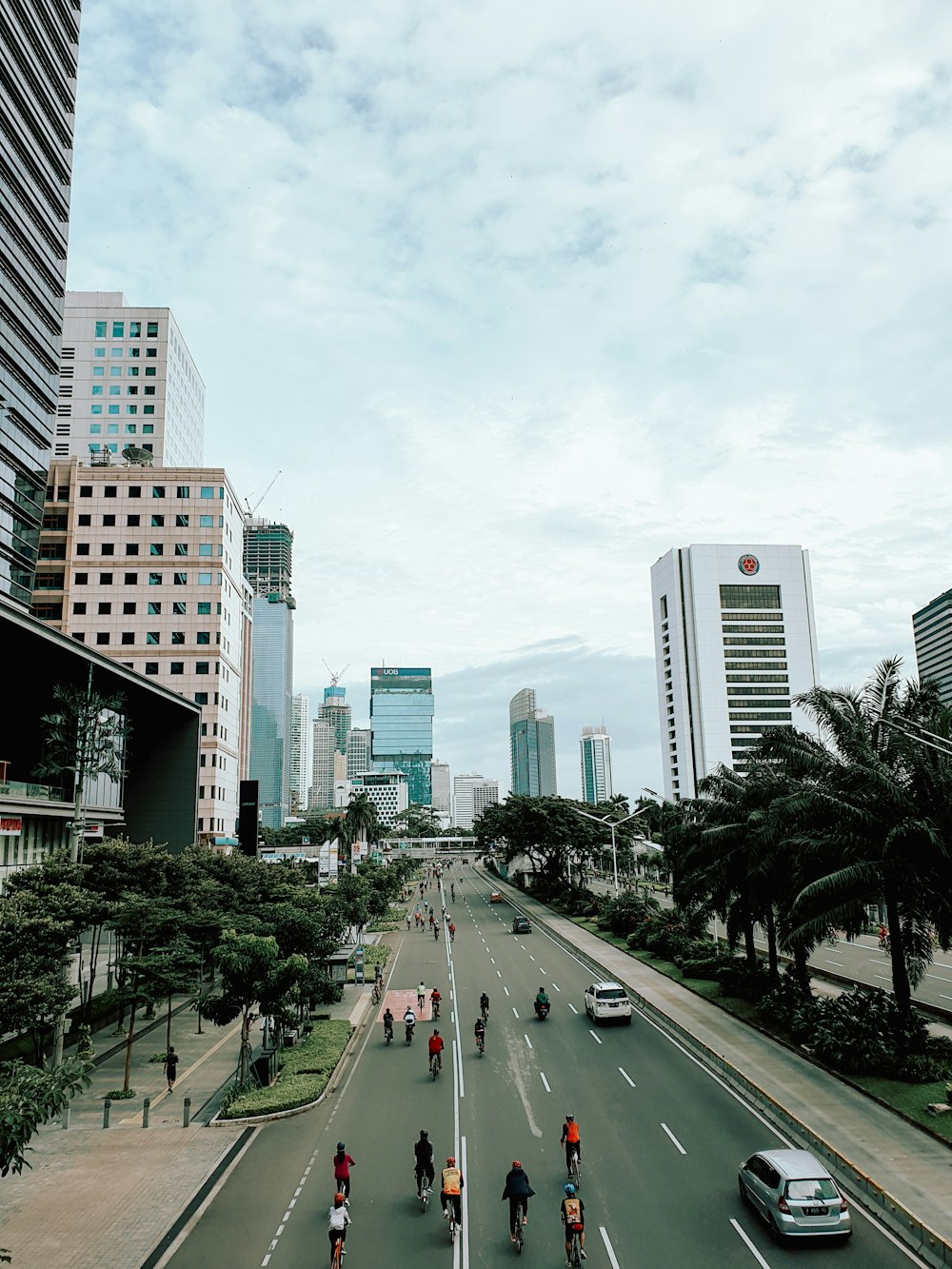 cars on road between high rise buildings during daytime