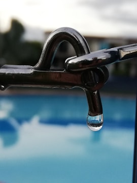Close-up of a sleek pool automation controller installed near a swimming pool.