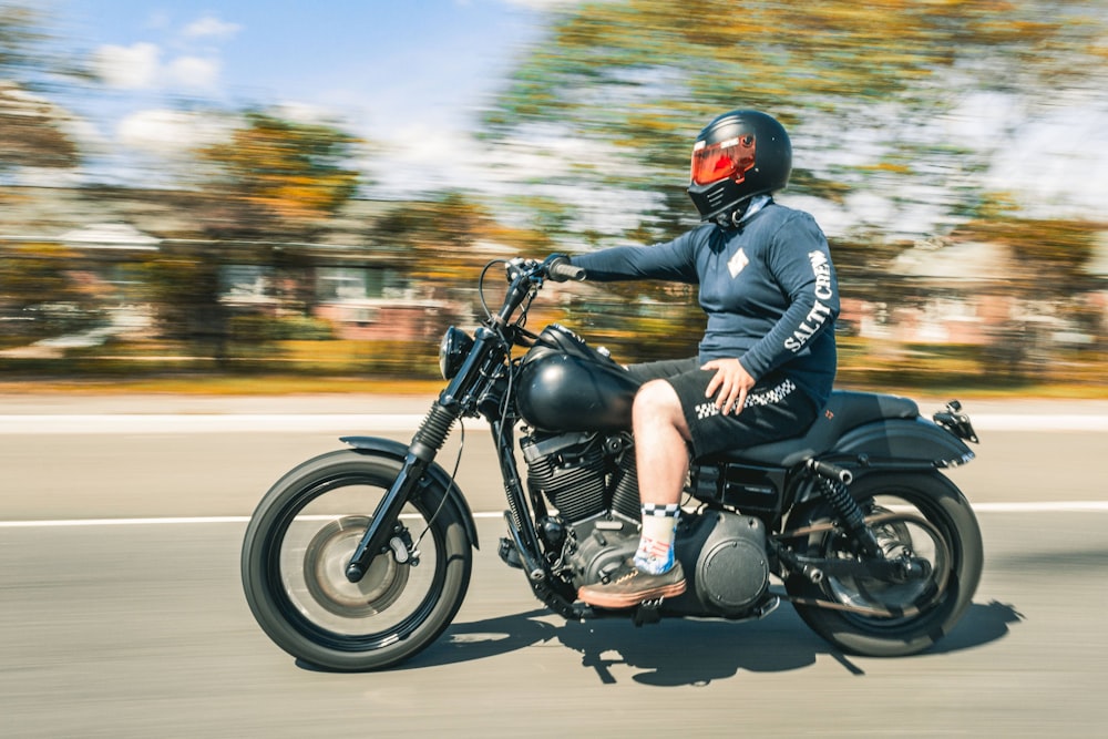 man in blue jacket riding black motorcycle