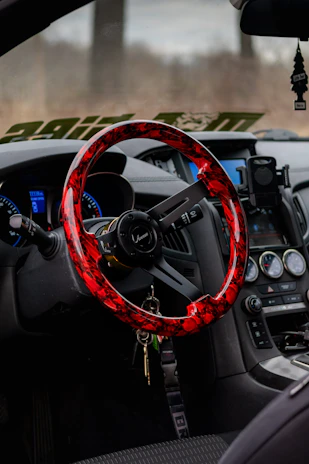 A vibrant red steering wheel cover wrapped snugly around a car's steering wheel.