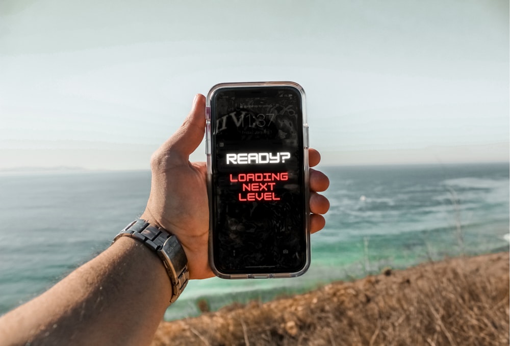 person holding black iphone 5 taking photo of sea during daytime