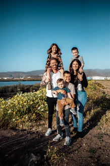 A family in Ensenada with two adults holding four children in a field
