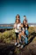 Family Visa Services – Happy family standing together outdoors on green grass