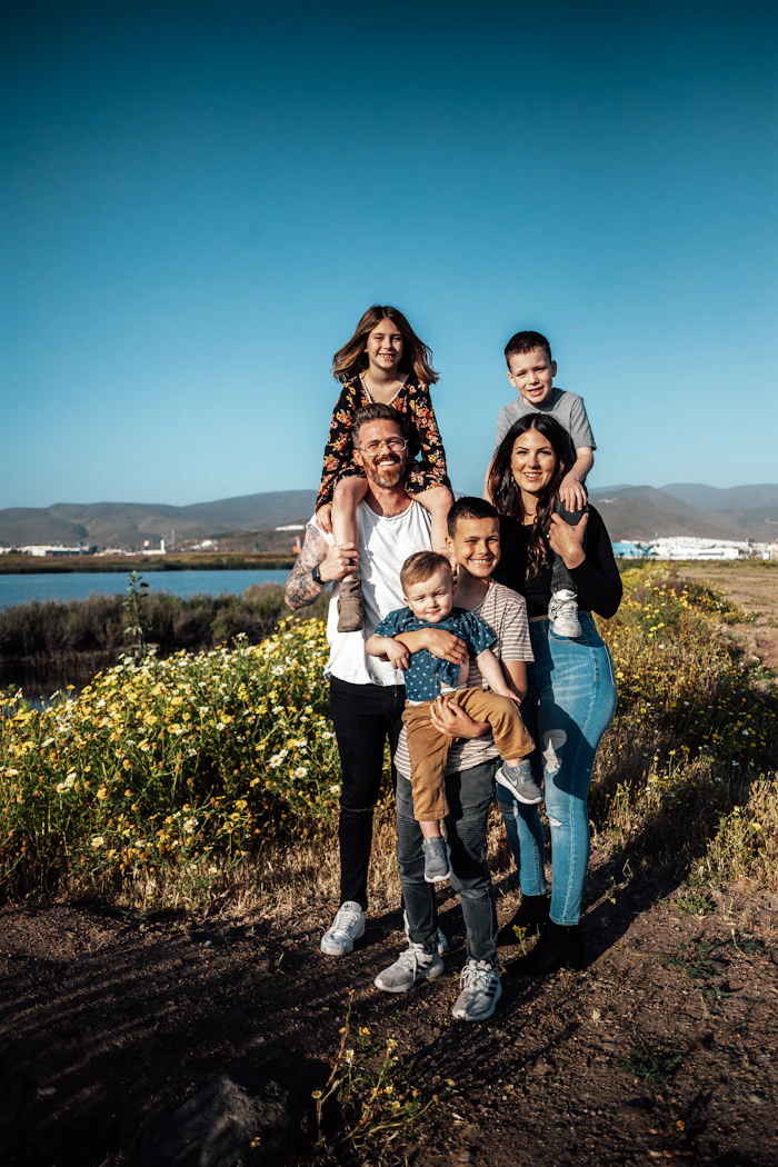 Família reunida sorrindo em um campo verde
