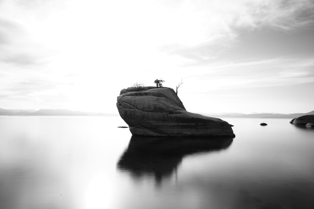 grayscale photo of a boat on a lake