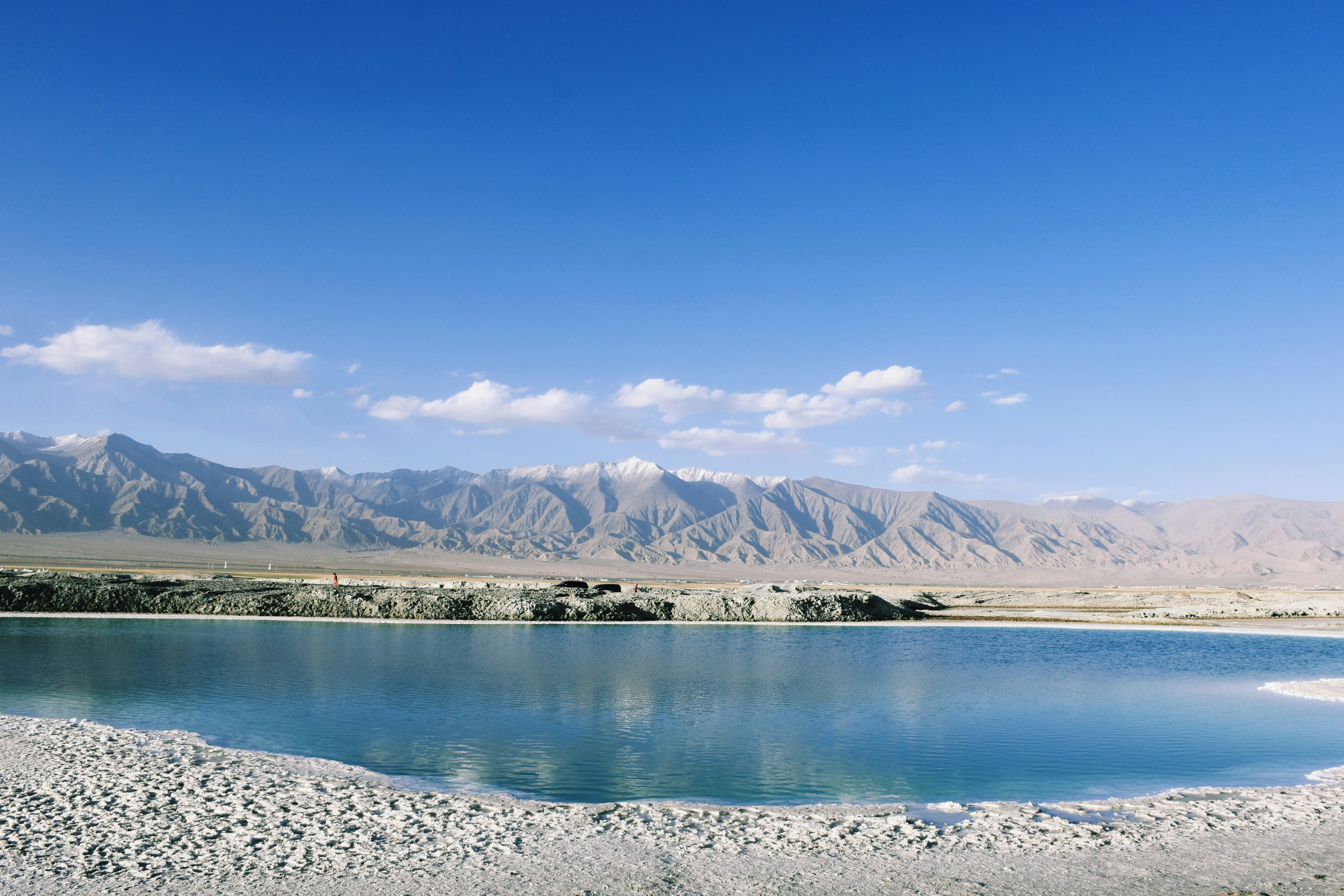 lake near mountain under blue sky during daytime