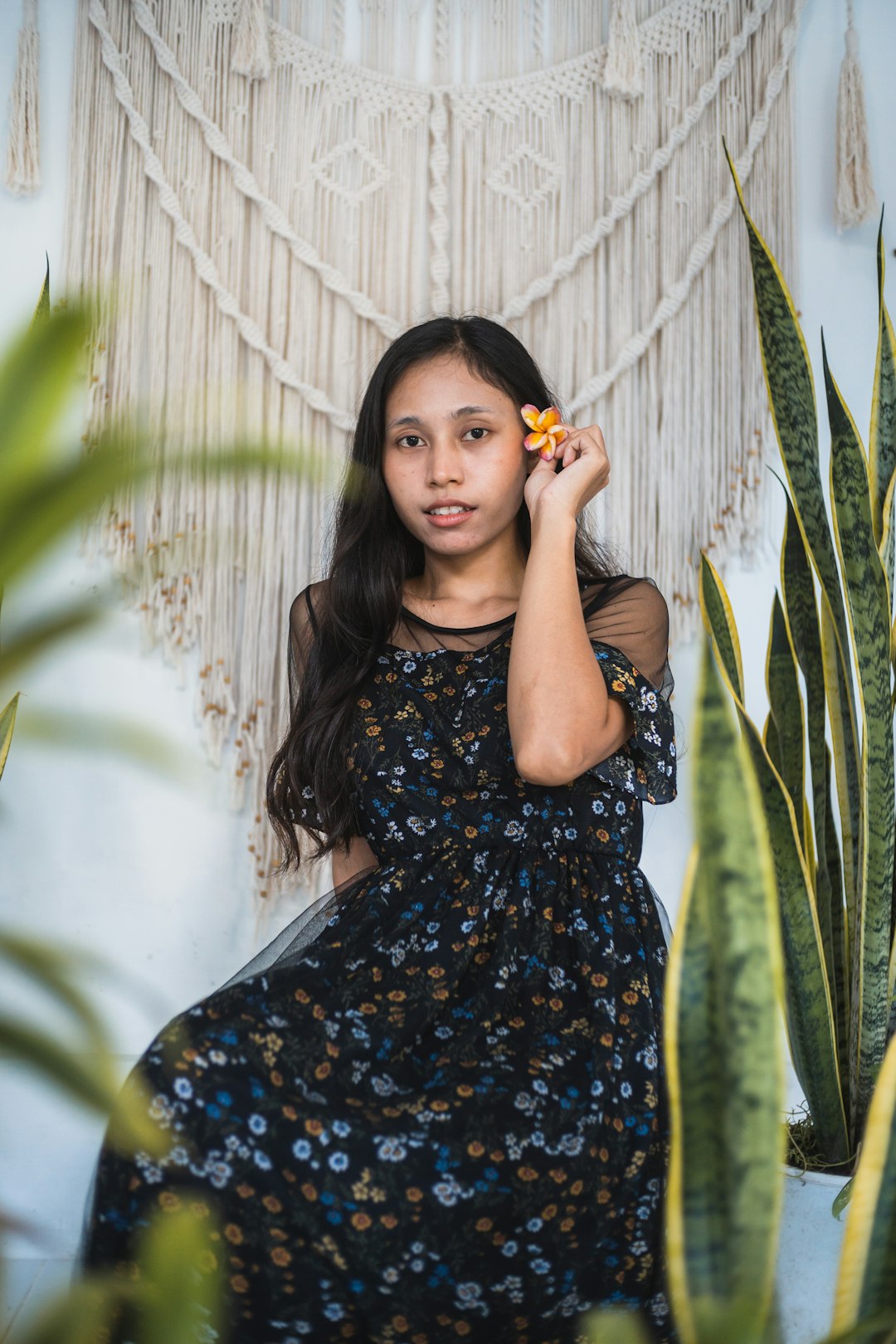 woman in blue and white floral dress standing near green plant