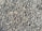 A densely packed pile of small, irregularly shaped gray and brown stones with various textures and shades. The stones appear rough and are closely arranged, suggesting they might be used for construction or landscaping purposes.
