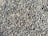 A densely packed pile of small, irregularly shaped gray and brown stones with various textures and shades. The stones appear rough and are closely arranged, suggesting they might be used for construction or landscaping purposes.