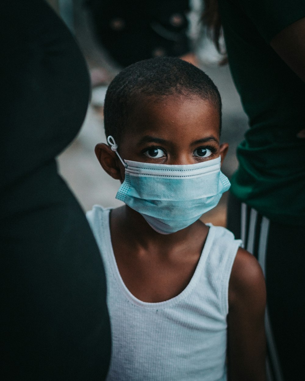 boy in white tank top with face mask