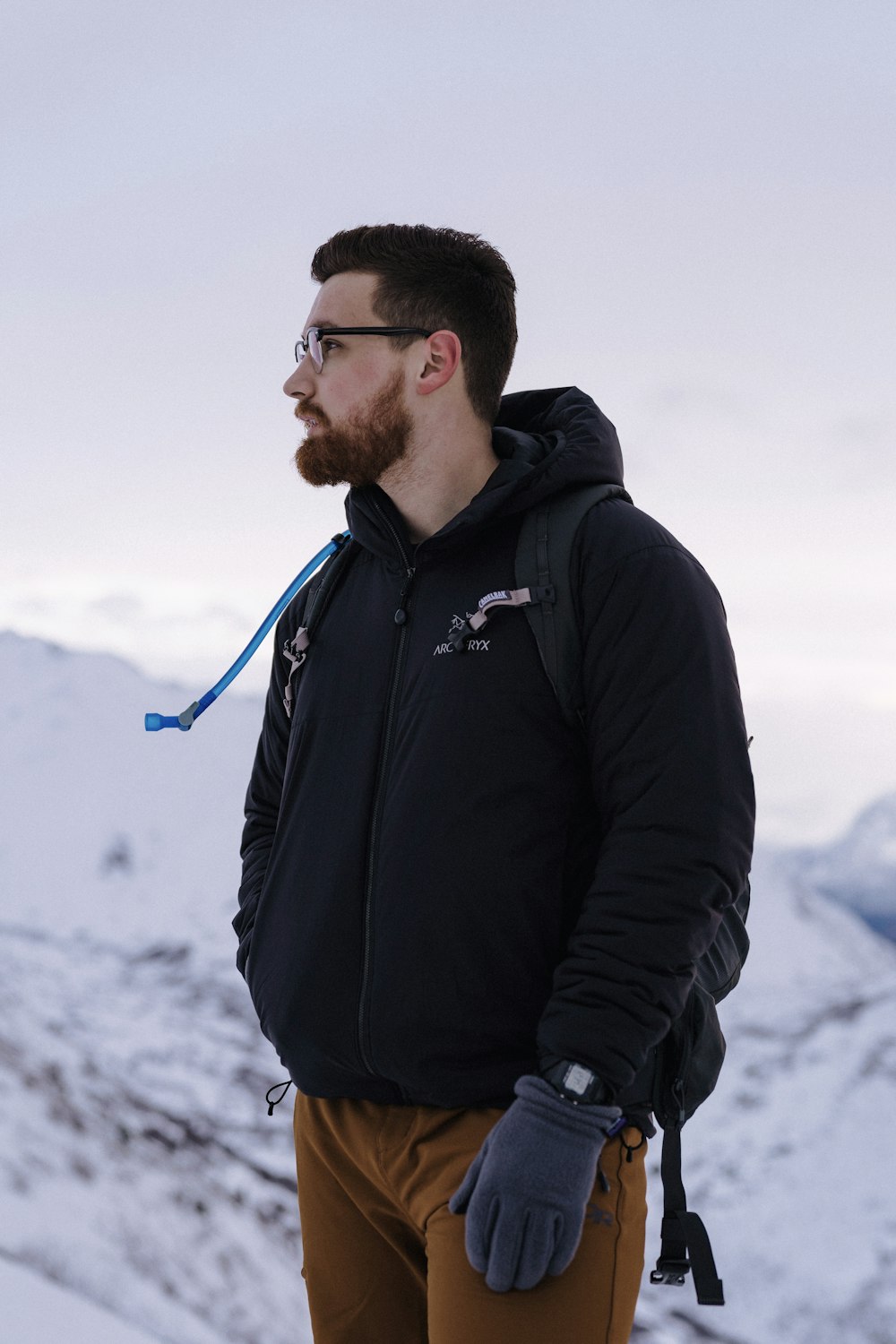 man in black jacket standing on snow covered ground during daytime