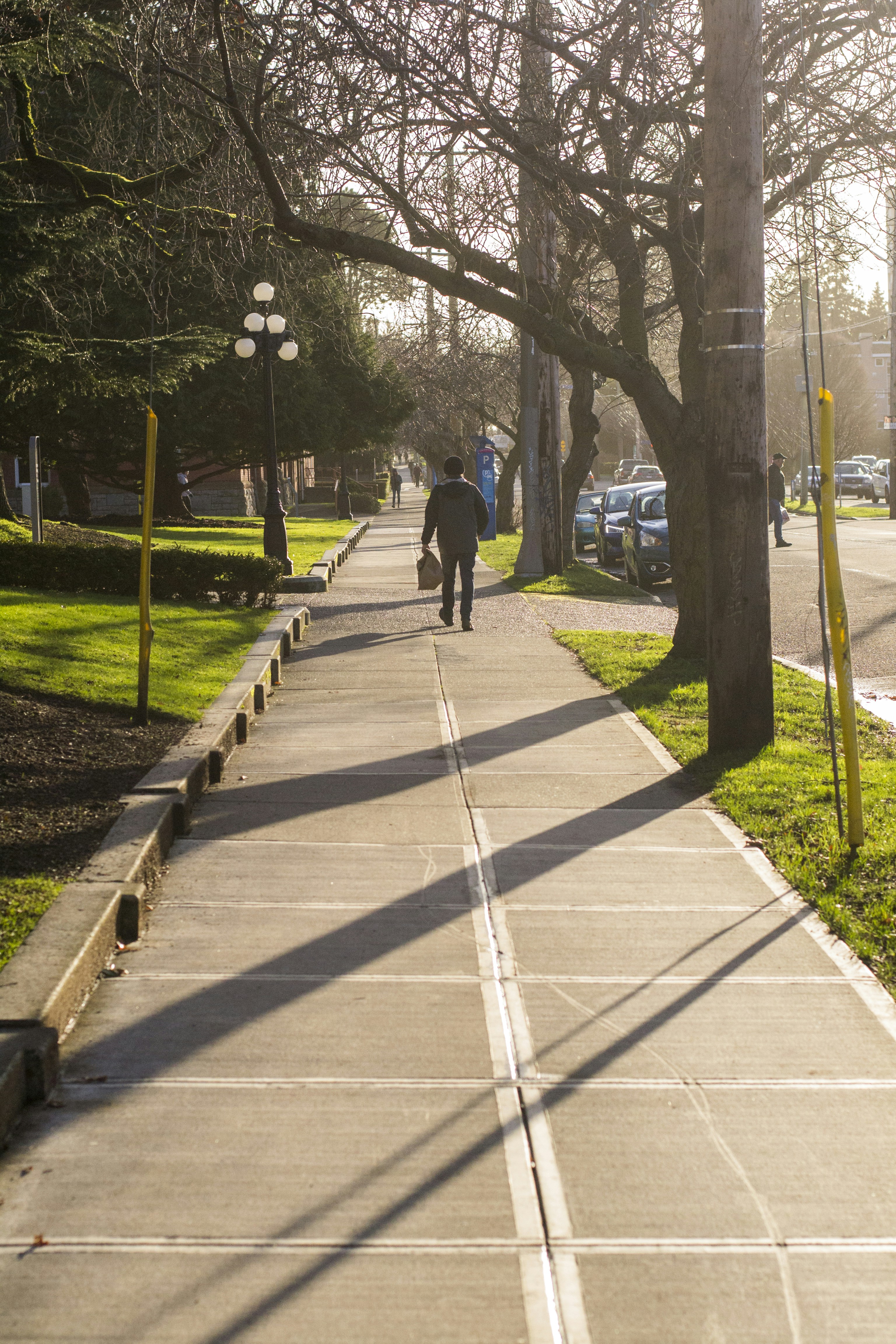 man in black jacket walking on sidewalk during daytime