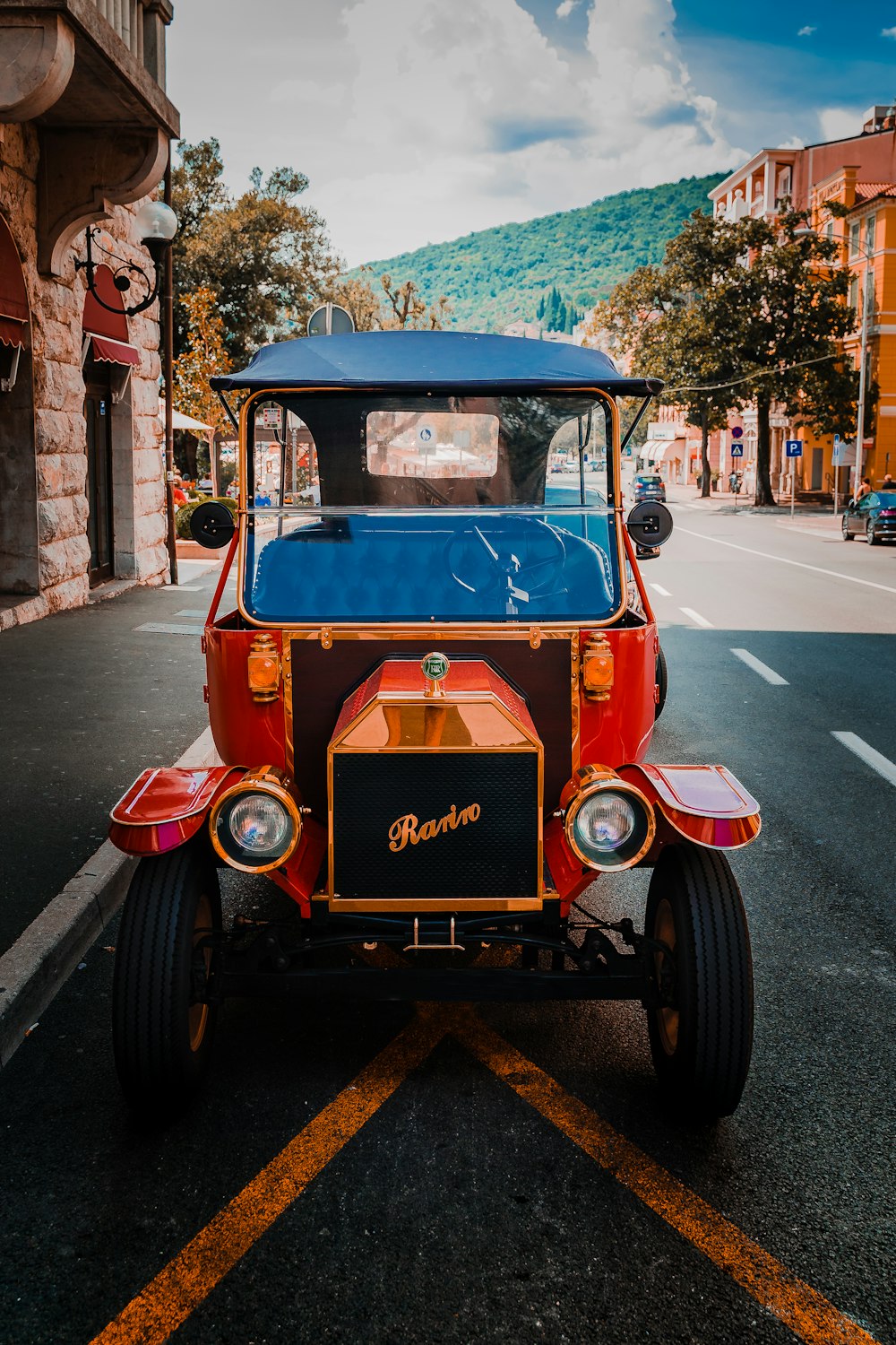 red vintage car on road during daytime