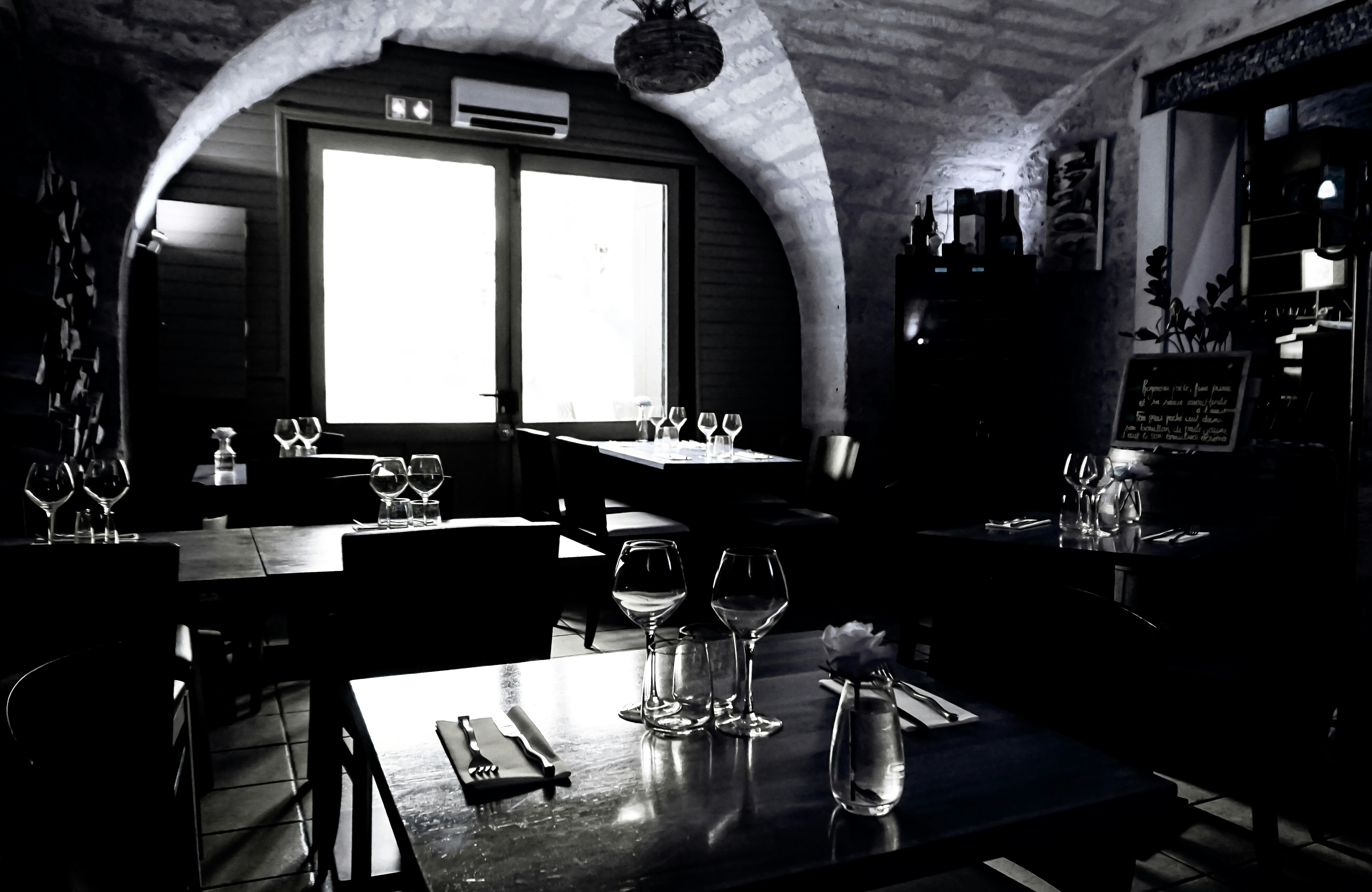 Michelin restaurant dark ambient dining room, candlelight, deep shadows, intimate atmospheric lighting