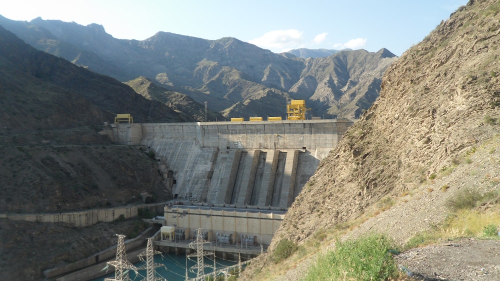 gray concrete dam near mountain during daytime