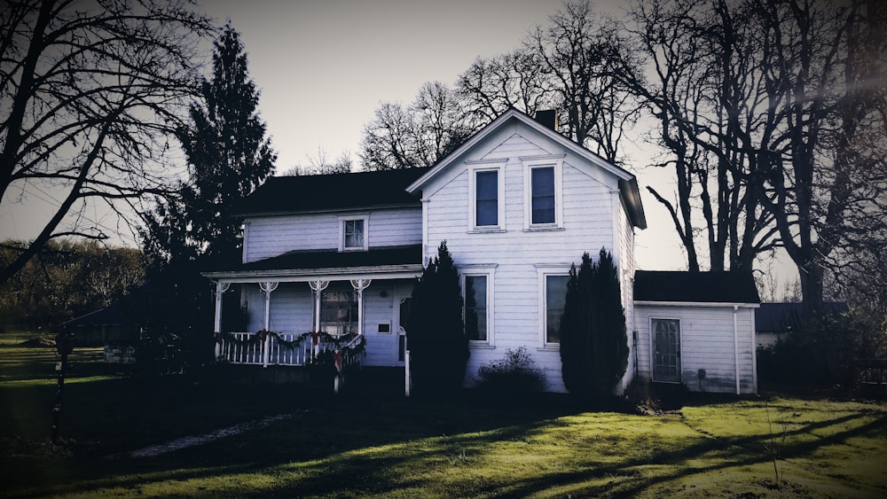 white wooden house near green trees during daytime