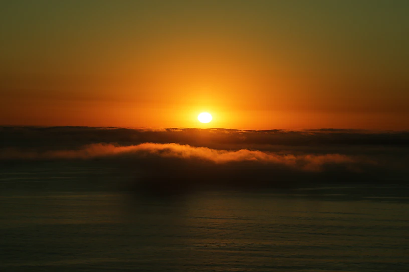 A warm golden sunset over a calm ocean, evoking dreams of travel and adventure.