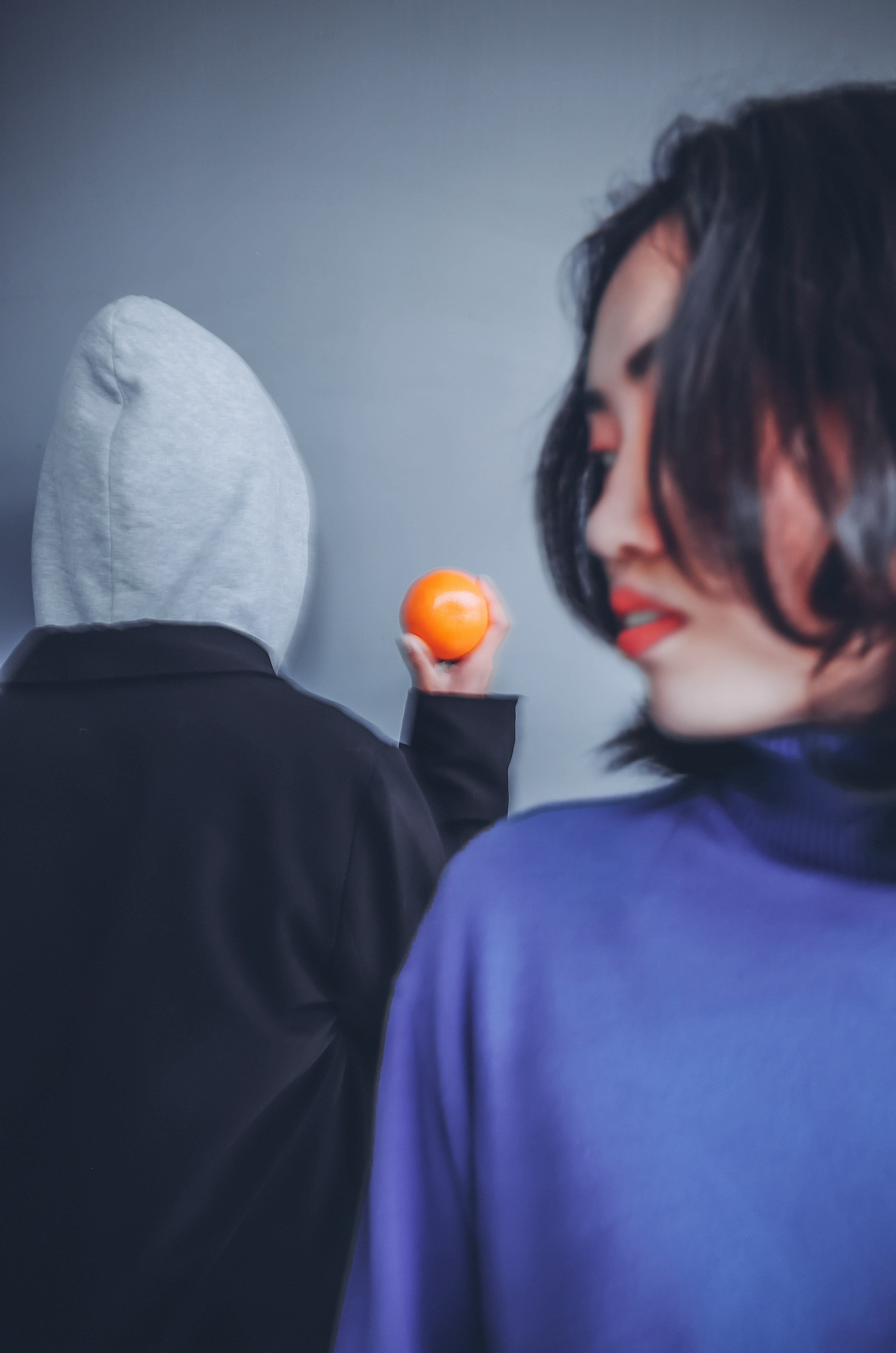 man in blue hoodie beside woman in black jacket