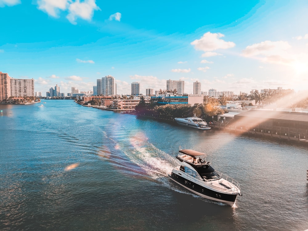 white and black boat on water near city buildings during daytime