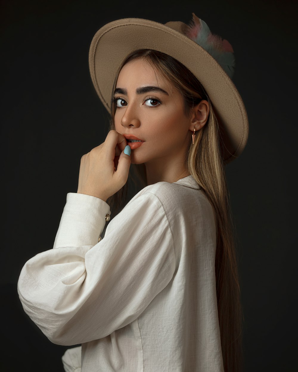 Femme en chemise blanche à manches longues portant un chapeau marron