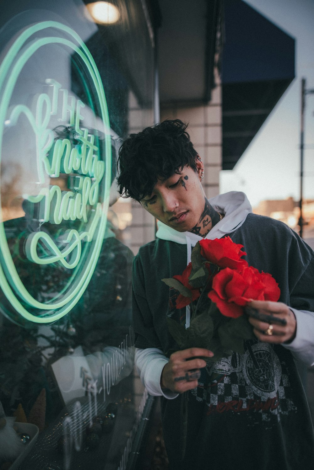 man in black suit holding red rose