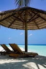 brown wooden lounge chairs on beach during daytime