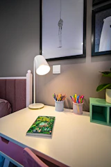 A cozy desk with a personalized dedication card and colored pencils scattered around.