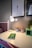 A styled desk featuring stationery, plants, and a glowing lamp, radiating a cozy atmosphere.