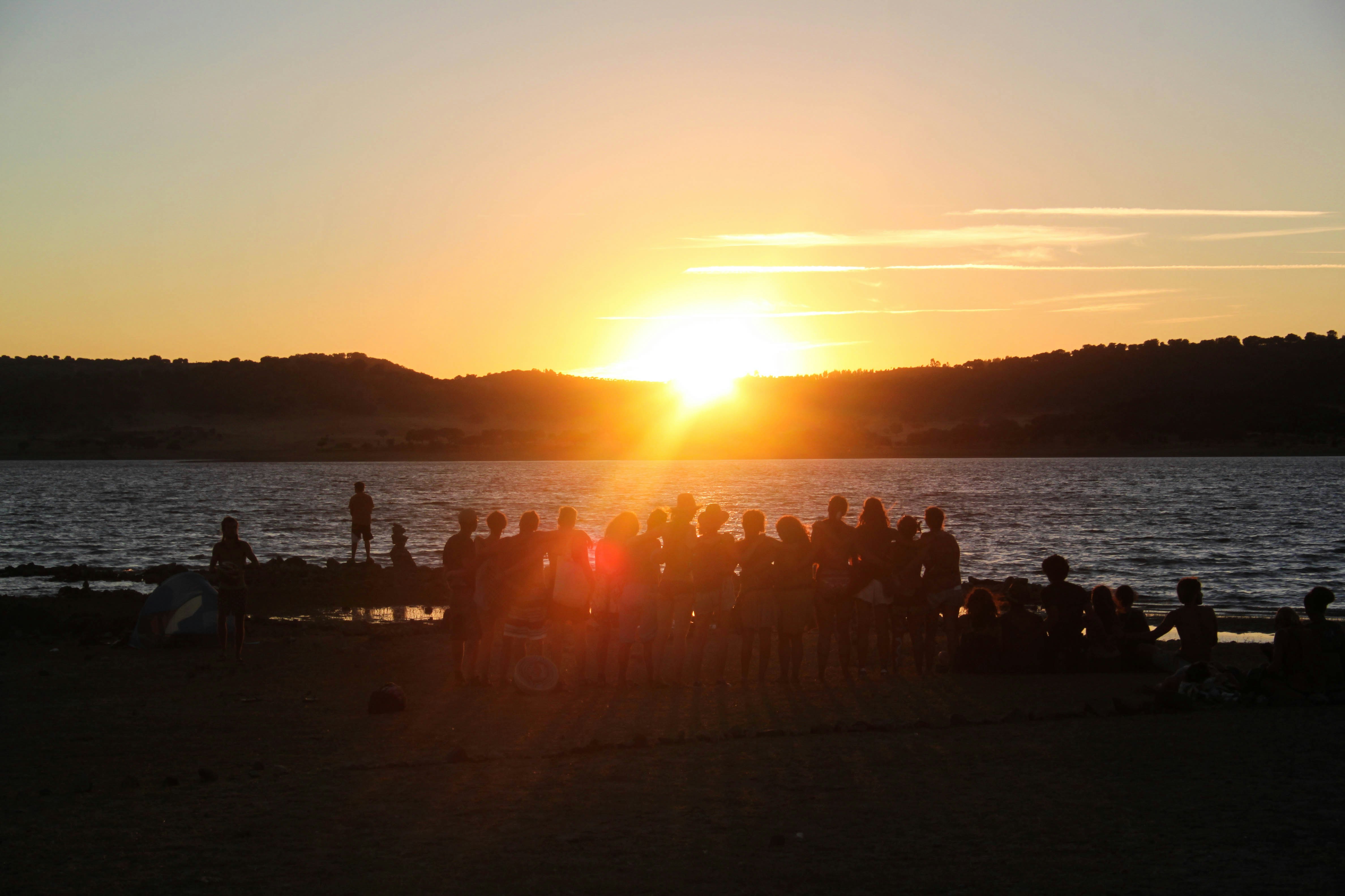 Silhouette von Menschen am Strand während des Sonnenuntergangs