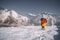 person in orange jacket standing on snow covered ground during daytime