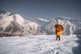 person in orange jacket standing on snow covered ground during daytime