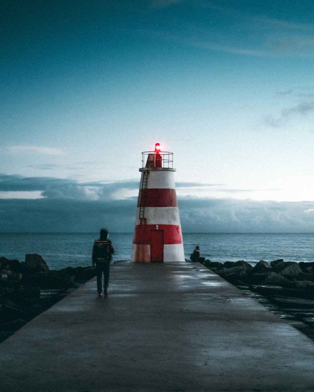 red and white lighthouse near body of water during daytime